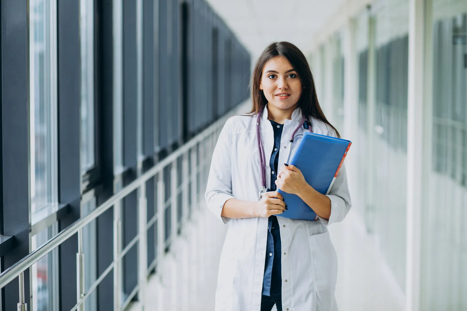 Nursing student with her study files in a hospital corridor
